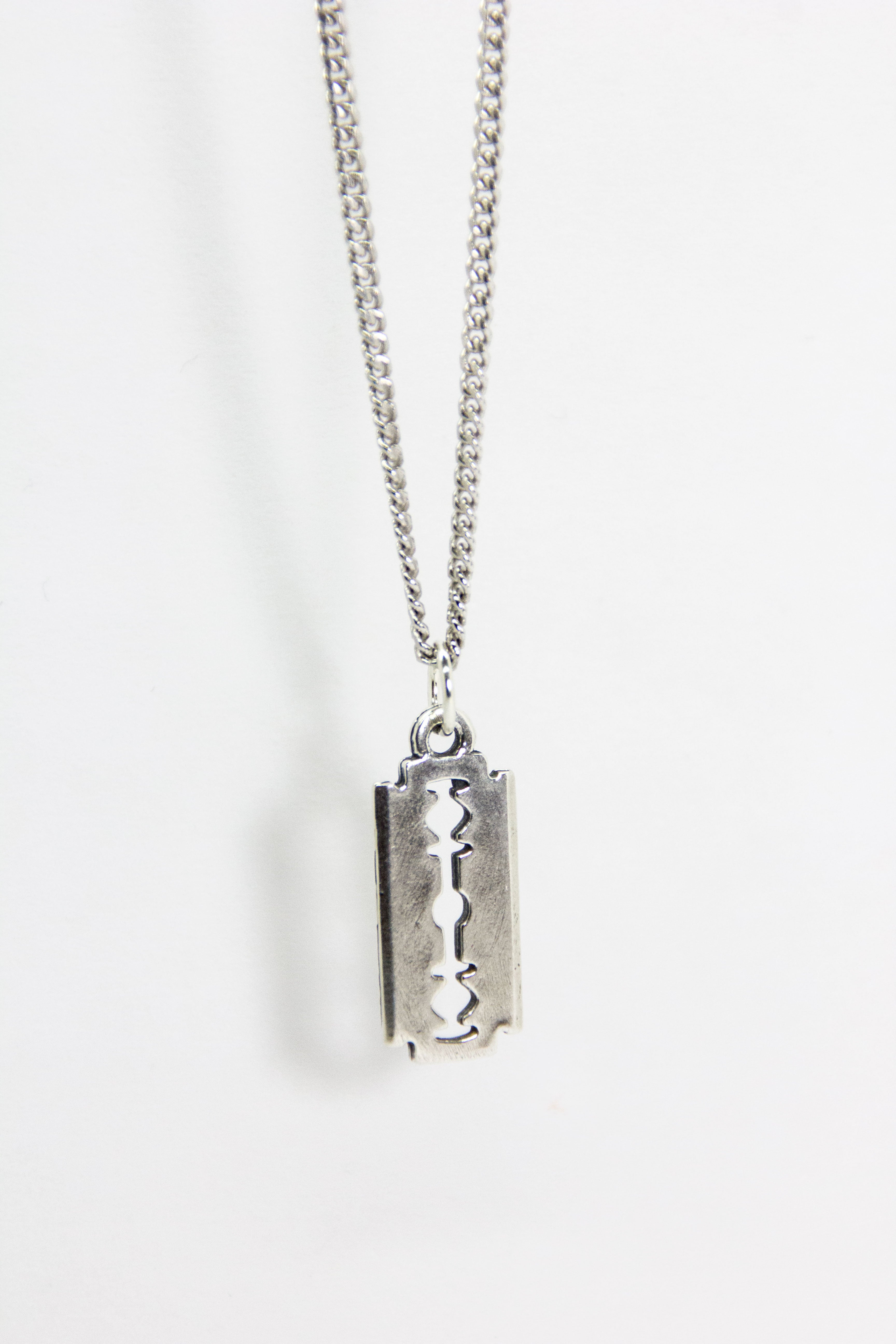 An “Addicted” silver razor blade necklace with diamonds